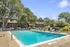 Inviting outdoor pool area with lounge chairs and lush greenery, perfect for relaxing and enjoying sunny days.