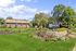 Inviting exterior view of ReNew Taunton on Winthrop with lush landscaped gardens and vibrant flower beds.