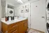 Contemporary bathroom with elegant wooden vanity, stacked washer-dryer, and modern decor.