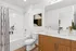 Bright and modern bathroom with elegant wooden cabinetry, sleek fixtures, and refreshing decor.