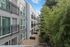 Modern apartment building exterior with sleek design, spacious balconies, and lush green surroundings.
