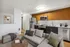 Modern open-concept living space featuring a sleek kitchen with stainless steel appliances and cozy seating area.