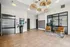Inviting apartment lobby with modern wicker lighting, sleek elevator, comfortable seating, and contemporary artwork.