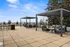 Spacious rooftop terrace with stylish pergolas, comfortable seating, and a stunning view of the tree-lined horizon, ideal for outdoor relaxation and entertainment.