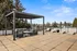 Spacious rooftop terrace featuring modern lounge seating under a sleek pergola and stylish sunbeds with scenic views.