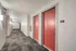 Modern apartment hallway with vibrant red doors and stylish carpet, creating an inviting entrance.