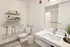 Modern bathroom with elegant marble vanity, large mirror, stylish shelving, and contemporary decor.