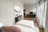Bright and modern open-concept studio apartment with stylish decor, cozy sleeping area, sleek TV setup, and large windows for ample natural light.