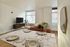 Modern living and dining area featuring elegant marble dining table, stylish furnishings, and large windows with scenic views.