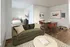 Cozy apartment interior featuring a chic green sofa, elegant dining area, and a stylishly furnished bedroom in a modern open-concept layout.