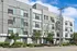Modern apartment building with sleek architecture, large windows, and well-maintained landscaping, offering a vibrant urban living experience.