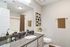 Elegant modern bathroom with granite countertop, large mirror, stylish decor, and inviting neutral tones.