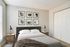 Elegant bedroom featuring a cozy double bed, chic bedside tables, modern lamps, and artistic photo gallery wall.