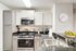 Modern kitchen with sleek granite countertops, stainless steel appliances, white cabinetry, and elegant decor.