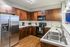 Modern kitchen with stainless steel appliances, elegant wooden cabinetry, and stylish subway tile backsplash.