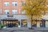 Charming urban building exterior with elegant entrance and vibrant autumn foliage, perfect for city living.