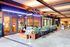 Charming restaurant entrance with stylish outdoor seating, lush greenery, and warm ambient lighting inviting you to dine.