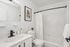 Elegant bathroom with modern fixtures, large mirror, and stylish white-tile design for a refreshing ambiance.