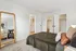 Elegant bedroom featuring a plush bed with stylish cushions, a full-length mirror, and a glimpse into the modern bathroom, showcasing spacious closets and chic decor.