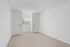 Bright, freshly painted room with plush carpeting and ample natural light from the window, ideal for a cozy bedroom or office space.