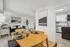 Modern apartment interior with stylish dining area, elegant table setting, cozy living room with green sofa, and contemporary kitchen design.
