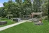 Beautiful outdoor living space with modern furniture, pergolas, and lush greenery in a private backyard setting.