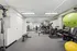 Modern apartment gym featuring state-of-the-art fitness equipment, ample free weights, and spacious workout areas for a dynamic exercise experience.