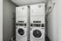 Modern laundry room with two advanced stacked washer and dryer units, offering efficient and convenient laundering solutions.