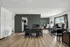 Modern office space with chic green accent wall, large windows with scenic views, and elegant wooden flooring.