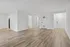 Bright and spacious open-floor apartment with elegant hardwood floors and modern white walls, offering a stylish and versatile layout.