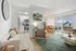Bright and modern living area with open-plan kitchen, cozy seating, and dining space leading to a balcony with scenic views.