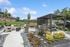 Inviting outdoor amenity area with modern pergola, cozy seating, and vibrant landscaping perfect for relaxation.