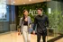 Modern lobby with stylish decor and a green wall, two people walking, showcasing a welcoming and vibrant atmosphere.