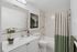 Elegant bathroom with a marble countertop, chic tile accents, and fresh orchid decor.