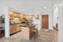Charming modern kitchen with sleek stainless steel appliances, warm wooden cabinetry, and inviting island seating, perfect for culinary enthusiasts.