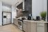 Modern kitchen with stainless steel appliances, elegant cabinetry, and stylish black hexagonal backsplash.
