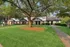 Charming townhome exterior with a lush green lawn, mature trees, and inviting pathways.
