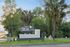 Inviting entry sign for The Social 2700, surrounded by lush green landscaping, palm trees, and a serene backdrop, highlighting welcoming student spaces.