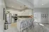 Modern kitchen with sleek stainless steel appliances, elegant pendant lighting, and a spacious breakfast bar with cozy seating.