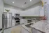 Elegant kitchen with modern stainless steel appliances, white cabinetry, and luxurious granite countertops, illuminated by chic pendant lights.