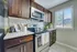 Modern kitchen with elegant dark wood cabinets, stainless steel appliances, and a bright window view.
