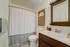 Charming bathroom with elegant fixtures, stylish dark wood vanity, and modern decor accents.