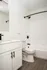 Contemporary bathroom with sleek fixtures, modern white vanity, and elegant wood flooring.