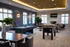 Luxurious game room featuring a sleek billiards table, foosball, and plush seating in a sunlit, modern apartment community.