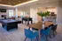Modern community lounge featuring pool and foosball tables, a stylish dining area, and a sleek kitchen with bar seating, perfect for social gatherings.