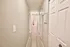 Elegant apartment hallway with modern flooring leading to a bright and inviting bathroom.