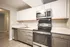 Modern kitchen with sleek stainless steel appliances, bright cabinetry, and elegant countertops.