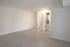 Modern open space with sleek wood flooring, bright white walls, and convenient in-unit laundry closet.