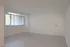 Bright, open-concept living space with sleek laminate flooring and large window offering natural light.