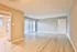 Contemporary open-plan living space featuring sleek laminate floors and abundant natural light, perfect for modern living.